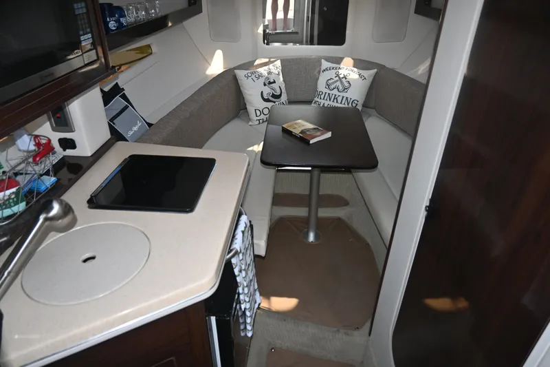 Slide: The Image of 2018 Sea Ray Sundancer 260 cabin interior with kitchenette and cozy seating area. - 1