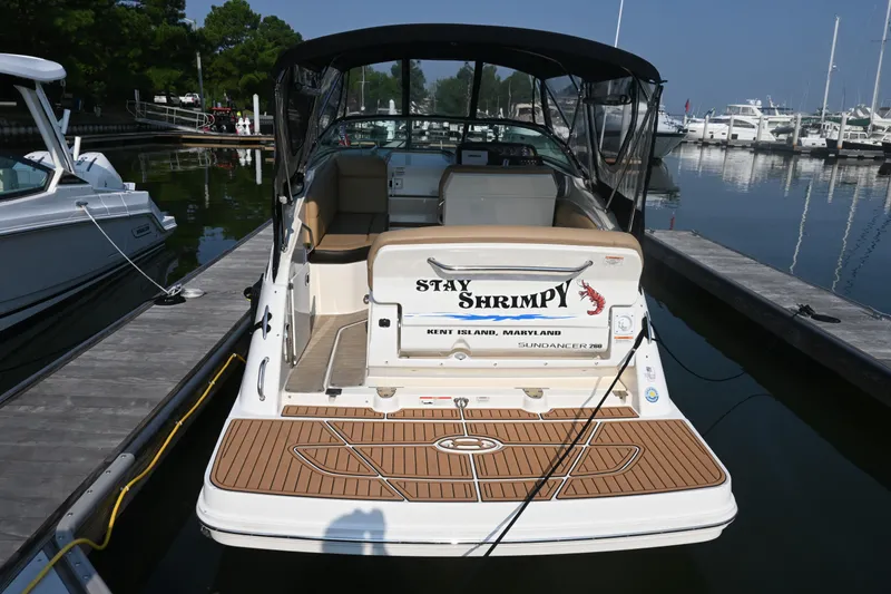 Slide: The Image of 2018 Sea Ray Sundancer 260 docked at marina, rear view with "Stay Shrimpy" name. - 10