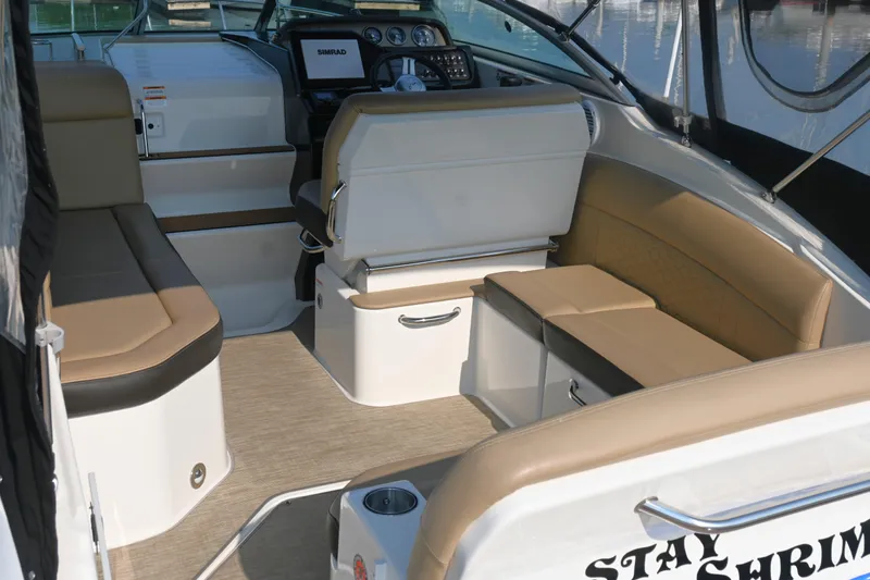 Slide: The Image of 2018 Sea Ray Sundancer 260 interior with beige seating and modern dashboard. - 18