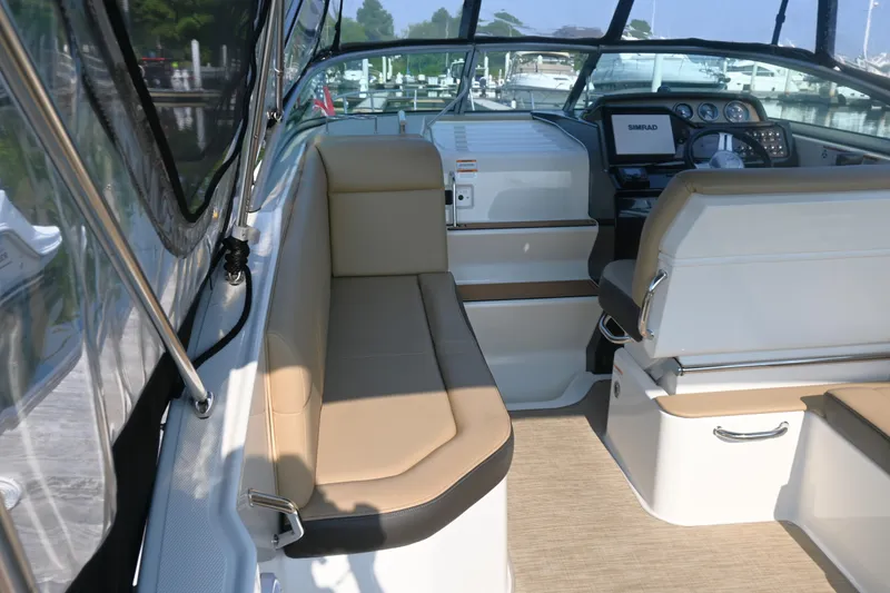 Slide: The Image of 2018 Sea Ray Sundancer 260 interior with beige seating and modern dashboard. - 19