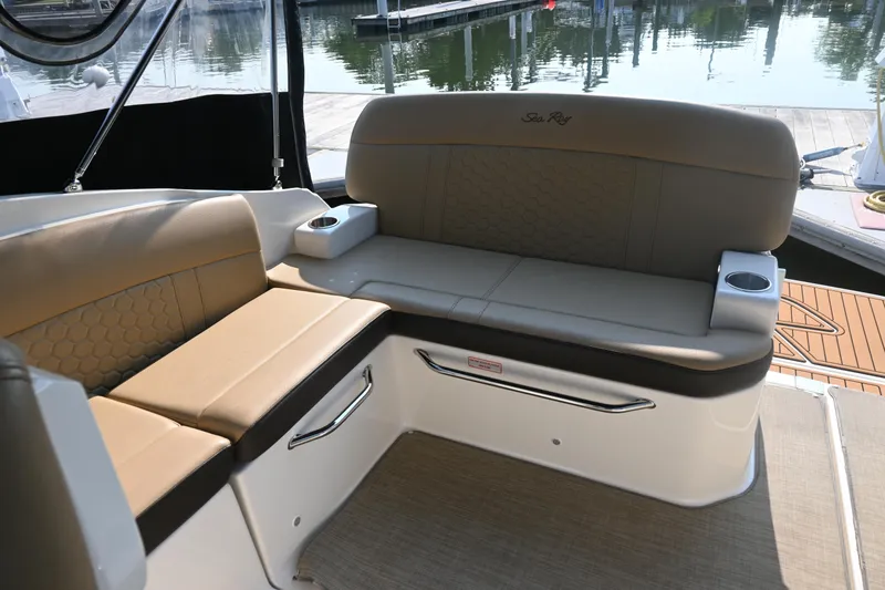 Slide: The Image of 2018 Sea Ray Sundancer 260 interior seating with beige upholstery and cup holders. - 2