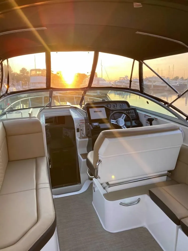 Slide: The Image of 2018 Sea Ray Sundancer 260 interior with sunset view, featuring helm and seating area. - 20