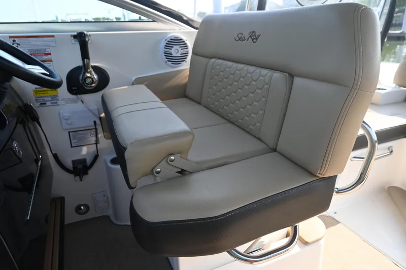 Slide: The Image of Captain's seat of 2018 Sea Ray Sundancer 260 boat, featuring beige upholstery and armrest. - 21