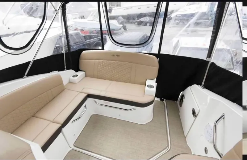 Slide: The Image of 2018 Sea Ray Sundancer 260 interior with beige seating and panoramic windows. - 3