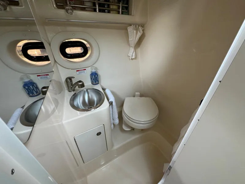 Slide: The Image of 2018 Sea Ray Sundancer 260 bathroom with sink, toilet, and porthole window. - 33