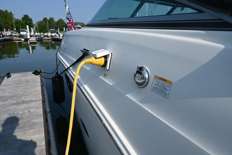 Slide: The Image of 2018 Sea Ray Sundancer 260 docked, showing power connection and marina background. - 36