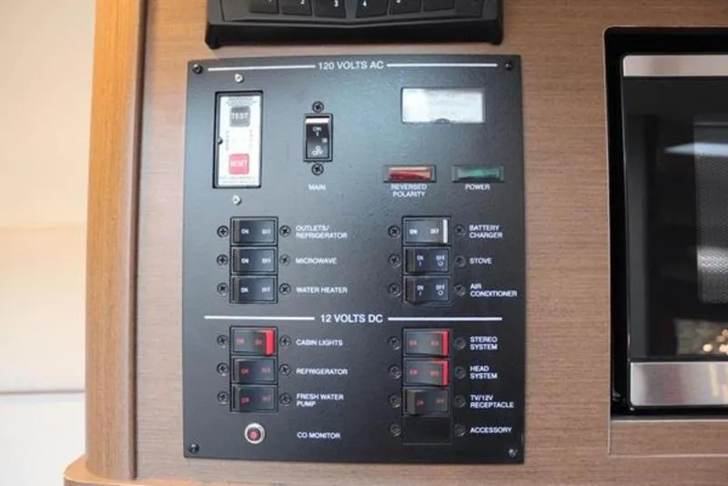 Slide: The Image of Control panel of a 2018 Sea Ray Sundancer 260 boat, featuring AC and DC switches. - 38