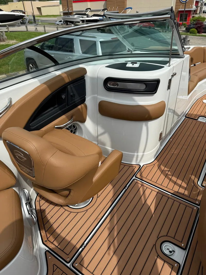 Slide: The Image of 2025 Crownline 290 SS boat interior with tan seating and wood-style flooring. - 10