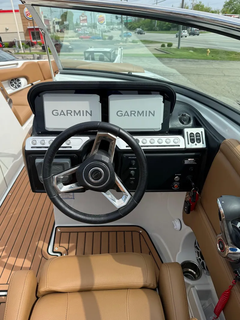 Slide: The Image of 2025 Crownline 290 SS boat dashboard with dual Garmin displays and leather seating. - 11