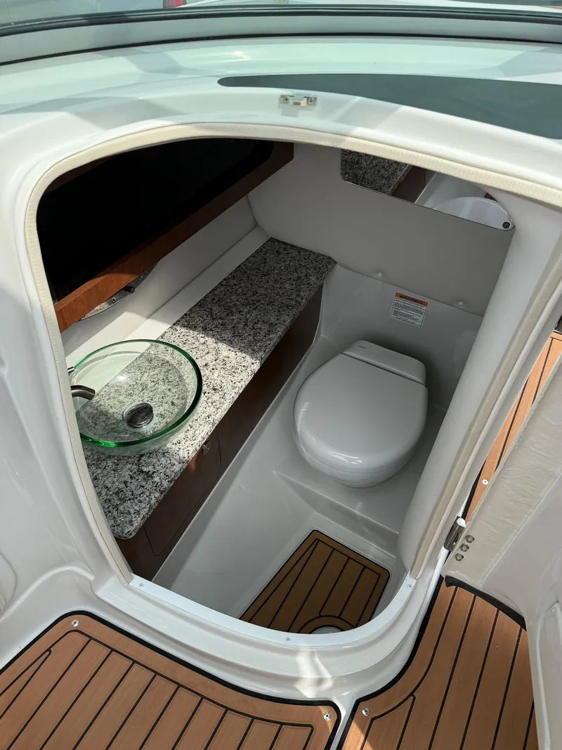 Slide: The Image of 2025 Crownline 290 SS boat bathroom with modern fixtures and wood flooring. - 9