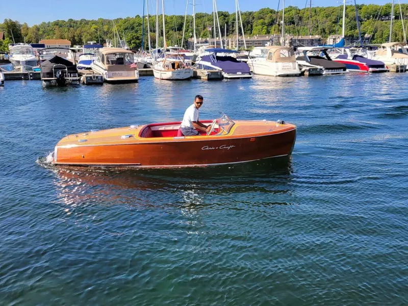 Slide: The Image of 1951 Chris-Craft Riviera 16 classic wooden boat cruising in a marina. - 2