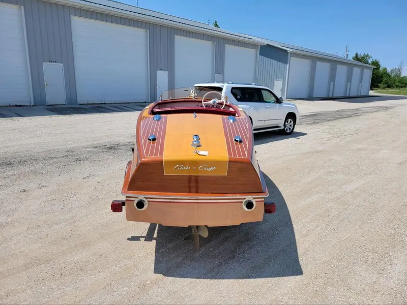 Slide: The Image of 1951 Chris-Craft Riviera 16 classic wooden boat parked near storage units. - 4