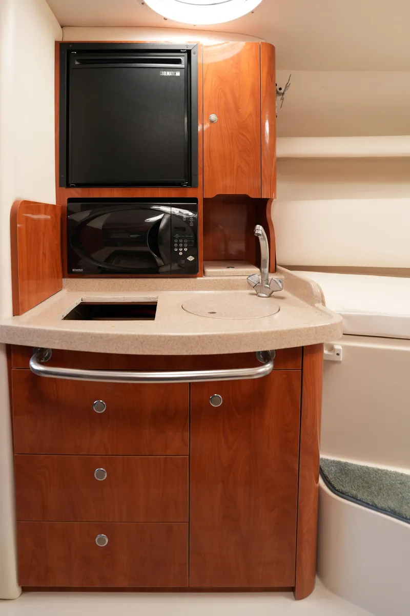 Slide: The Image of 2004 Four Winns Vista boat interior kitchen with microwave, sink, and refrigerator. - 15