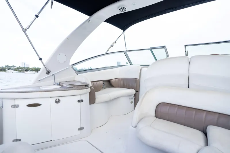 Slide: The Image of 2004 Four Winns Vista boat interior with white and beige seating, and a compact kitchenette. - 19