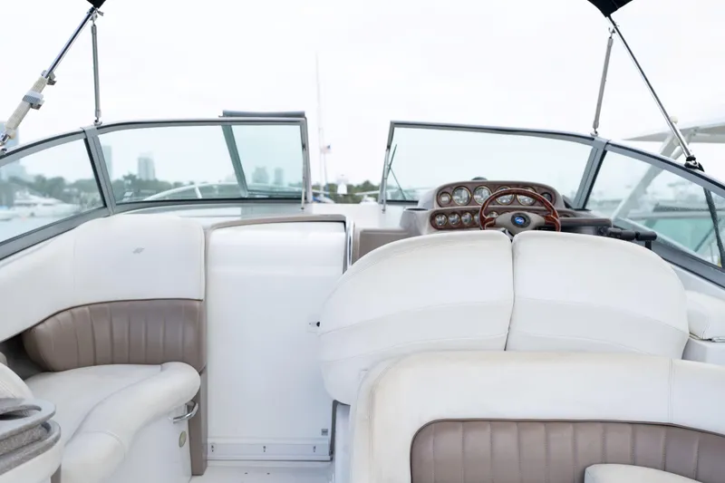 Slide: The Image of 2004 Four Winns Vista boat interior with white and beige seating, dashboard, and steering wheel. - 20