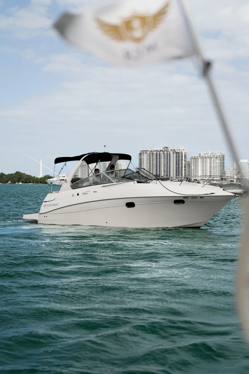 Slide: The Image of 2004 Four Winns Vista boat cruising on water with city skyline in background. - 7