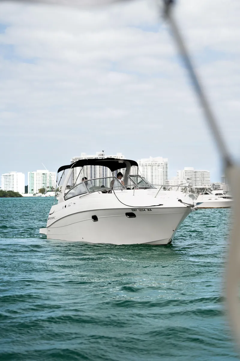 Slide: The Image of 2004 Four Winns Vista boat cruising on a sunny day with city skyline in the background. - 8