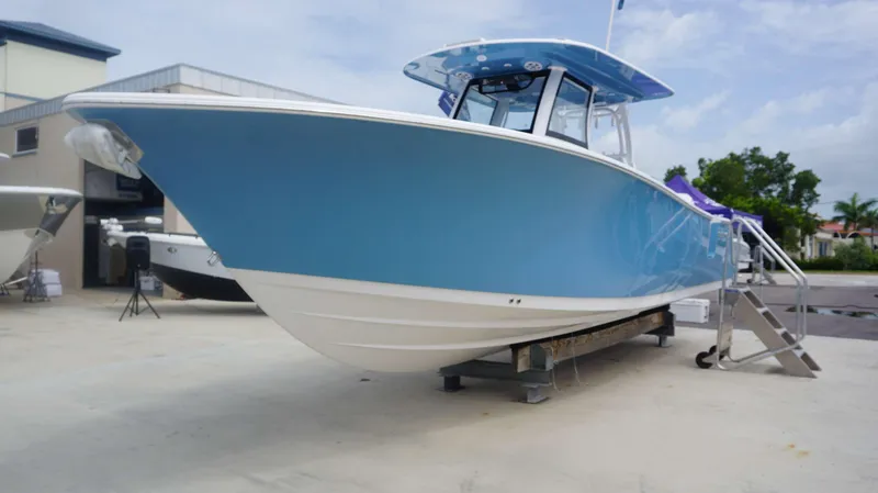 Slide: The Image of 2025 Sportsman 302 OPEN boat in blue, displayed outdoors on a stand. - 4
