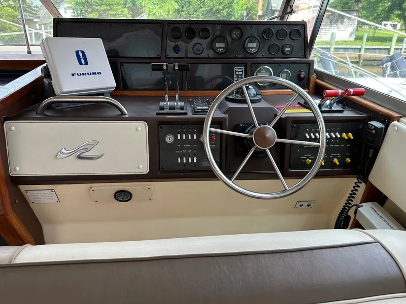 Slide: The Image of 1986 Sea Ray 390 Express Cruiser helm with steering wheel and control panel. - 11
