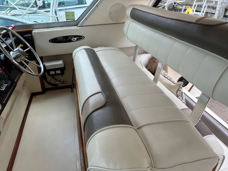 Slide: The Image of 1986 Sea Ray 390 Express Cruiser interior helm with beige and brown seating. - 13