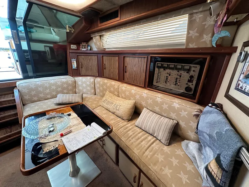 Slide: The Image of Interior of 1986 Sea Ray 390 Express Cruiser with beige star-patterned seating and control panel. - 15