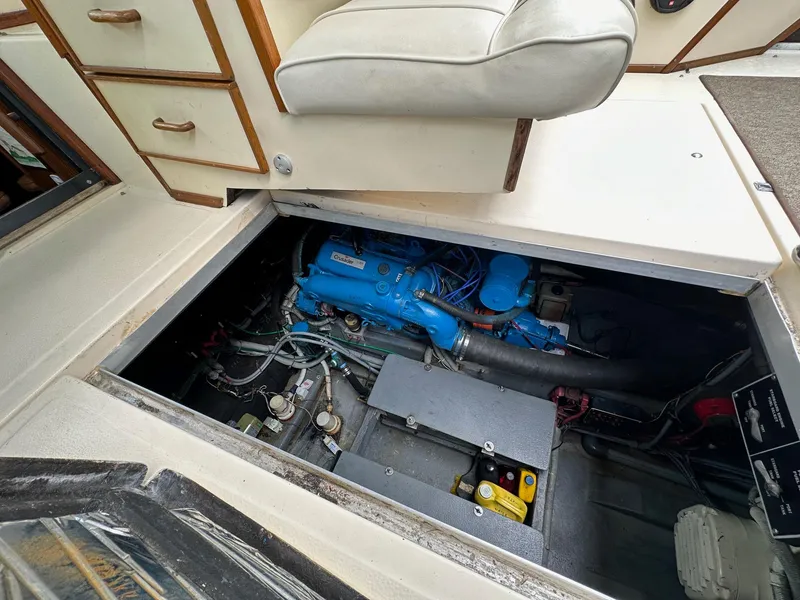 Slide: The Image of 1986 Sea Ray 390 Express Cruiser engine compartment with blue engine and storage drawers. - 26