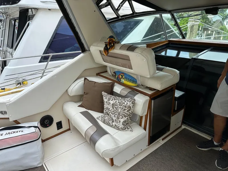 Slide: The Image of 1986 Sea Ray 390 Express Cruiser interior with cushioned seating and life jackets. - 8