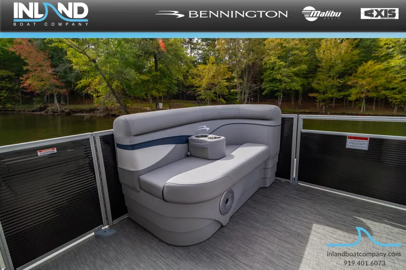 Slide: The Image of 2023 Bennington 20 SLM pontoon boat with comfortable seating on a serene lake. - 16