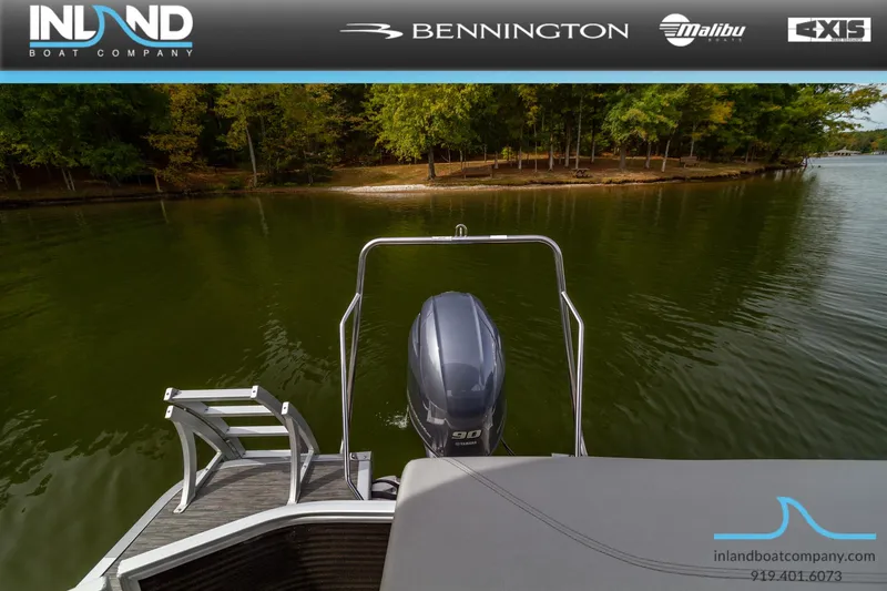 Slide: The Image of 2023 Bennington 20 SLM pontoon boat rear view with outboard motor on a lake. - 23