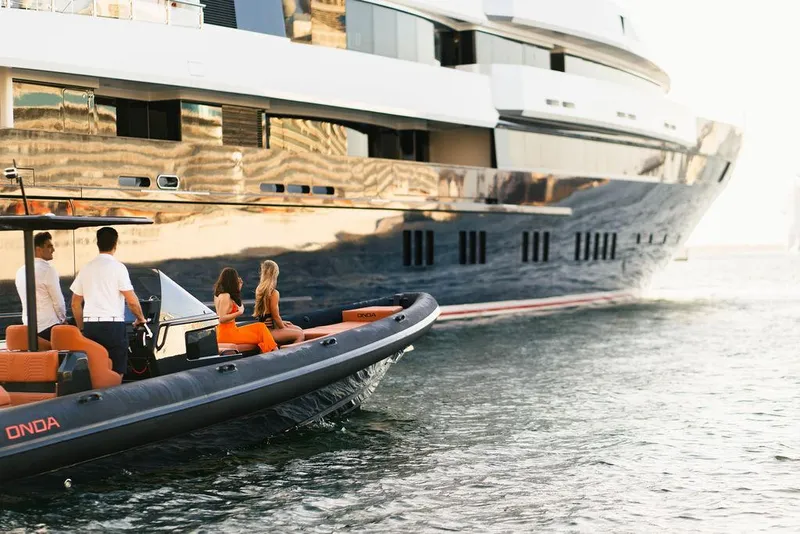 Slide: The Image of 2024 Onda Magna boat near a luxury yacht with people onboard. - 3