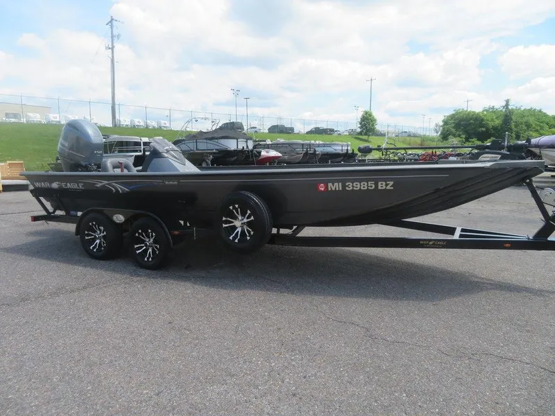 Slide: The Image of 2019 War Eagle 2170 boat on trailer, parked outdoors under cloudy sky. - 1