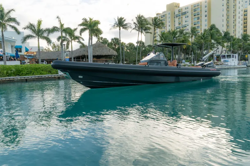 Slide: The Image of 2024 Onda Magna boat docked in a tropical marina with palm trees and buildings. - 0