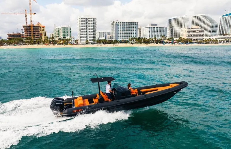 Slide: The Image of 2024 Onda Magna boat cruising near a city shoreline. - 8