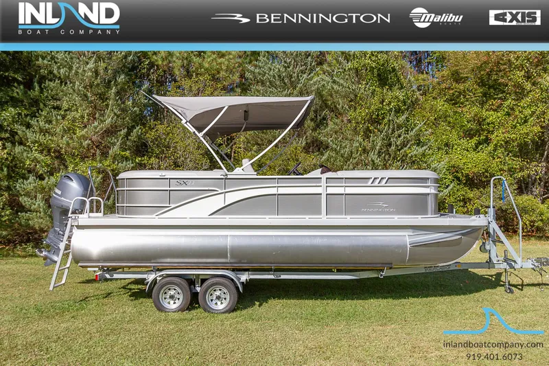The Image of 2023 Bennington 22 SXSR pontoon boat on a trailer with canopy, displayed by Inland Boat Company. - 0