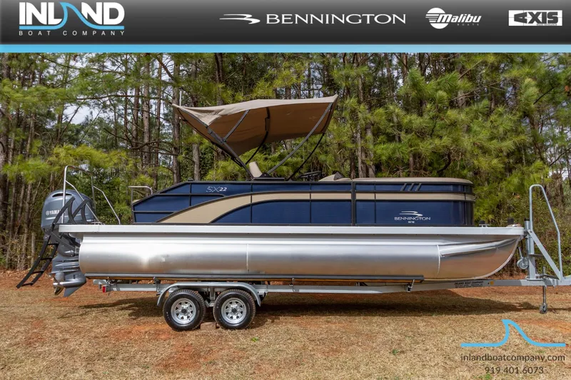 The Image of 2023 Bennington 22 SXSB pontoon boat on a trailer, displayed by Inland Boat Company. - 0