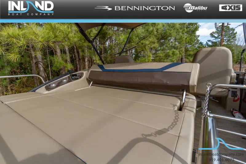Slide: The Image of 2023 Bennington 22 SXSB boat with tan seating and forest background. - 8