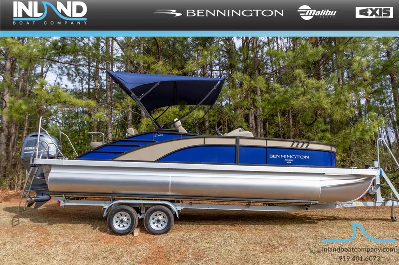 The Image of 2023 Bennington 23 LTSB pontoon boat on a trailer with a blue canopy. - 0