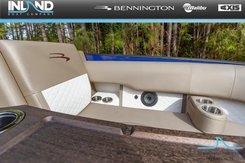Slide: The Image of 2023 Bennington 23 LTSB boat interior with beige and white seating, cup holders, and speaker. - 15