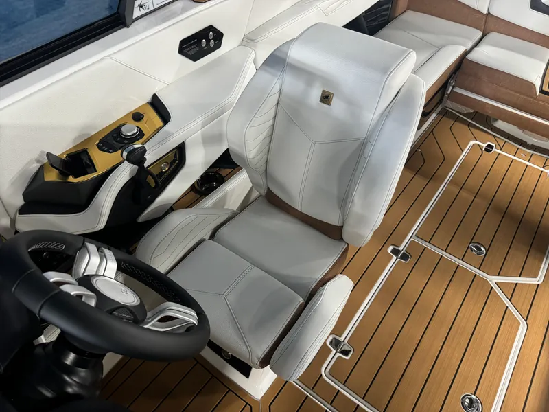 Slide: The Image of 2025 Nautique Super Air G23 interior with white seating and wood-style flooring. - 14