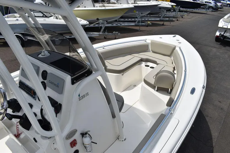 Slide: The Image of 2022 Key West 239FS boat interior with seating and console, parked in a marina. - 16