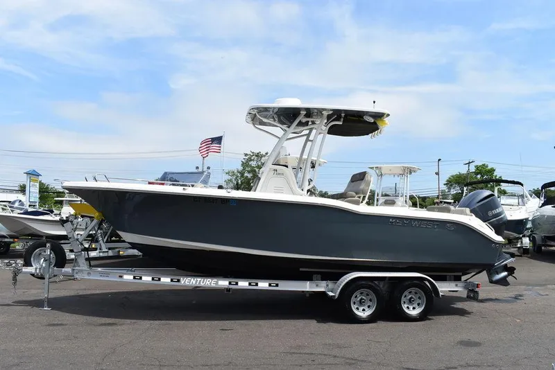 Slide: The Image of 2022 Key West 239FS boat on trailer, parked outdoors with American flag in background. - 3