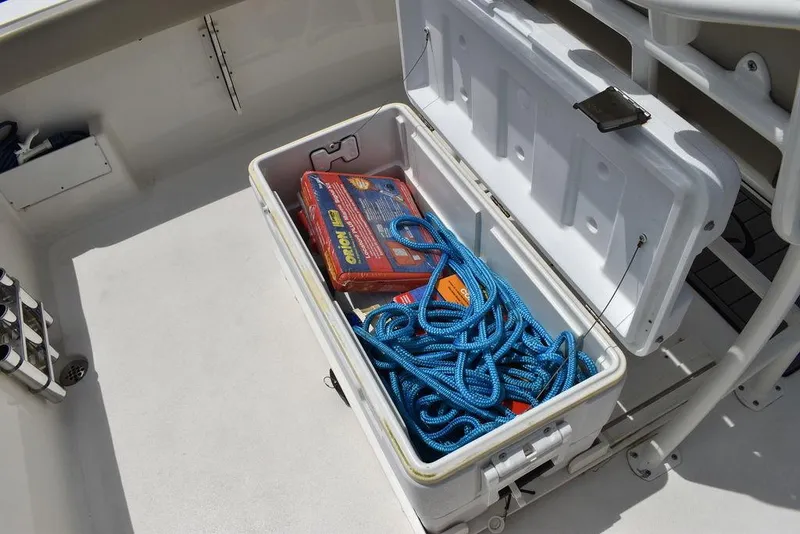 Slide: The Image of Open storage compartment on 2022 Key West 239FS boat with blue rope and gear. - 32