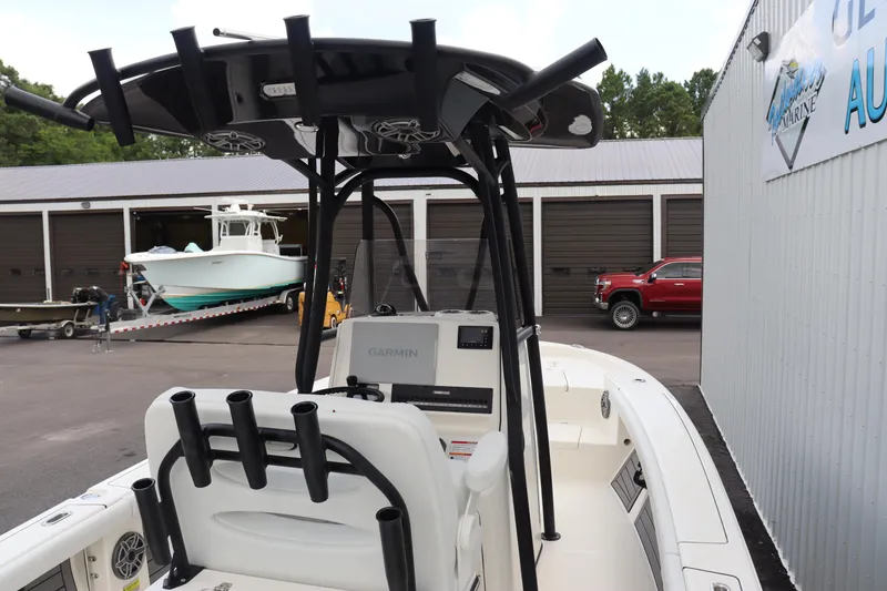 Slide: The Image of 2024 Pathfinder 2400 Open boat at a marina, featuring rod holders and Garmin electronics. - 13