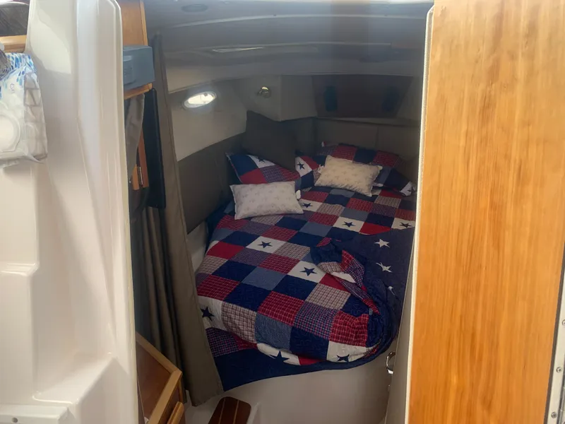 Slide: The Image of 2018 Cutwater C 302 Coupe cabin with a cozy bed and colorful quilt. - 13