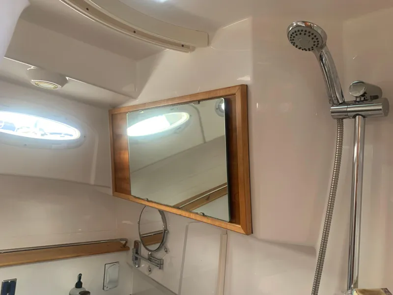 Slide: The Image of 2018 Cutwater C 302 Coupe bathroom with shower, mirror, and porthole window. - 16