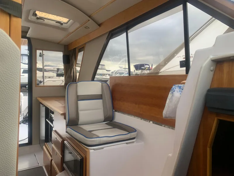 Slide: The Image of Interior of 2018 Cutwater C 302 Coupe boat with modern seating and wooden accents. - 7