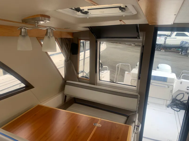 Slide: The Image of Interior of 2018 Cutwater C 302 Coupe boat with wooden table and seating. - 8