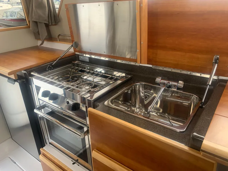 Slide: The Image of 2018 Cutwater C 302 Coupe kitchen with stainless steel stove and sink. - 9