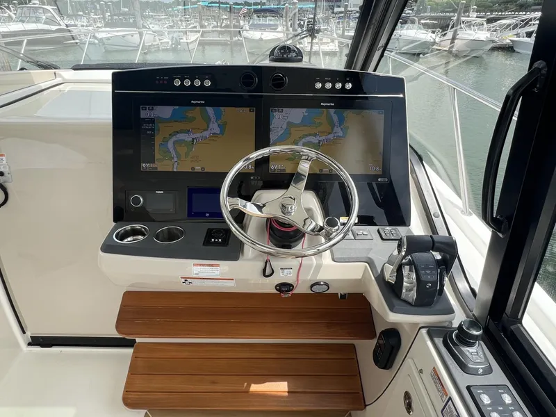 Slide: The Image of Boston Whaler 405 Conquest 2021 helm with dual navigation screens and steering wheel. - 13