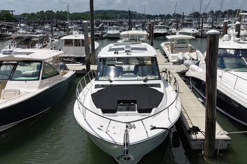 Slide: The Image of 2021 Boston Whaler 405 Conquest docked at a marina. - 2